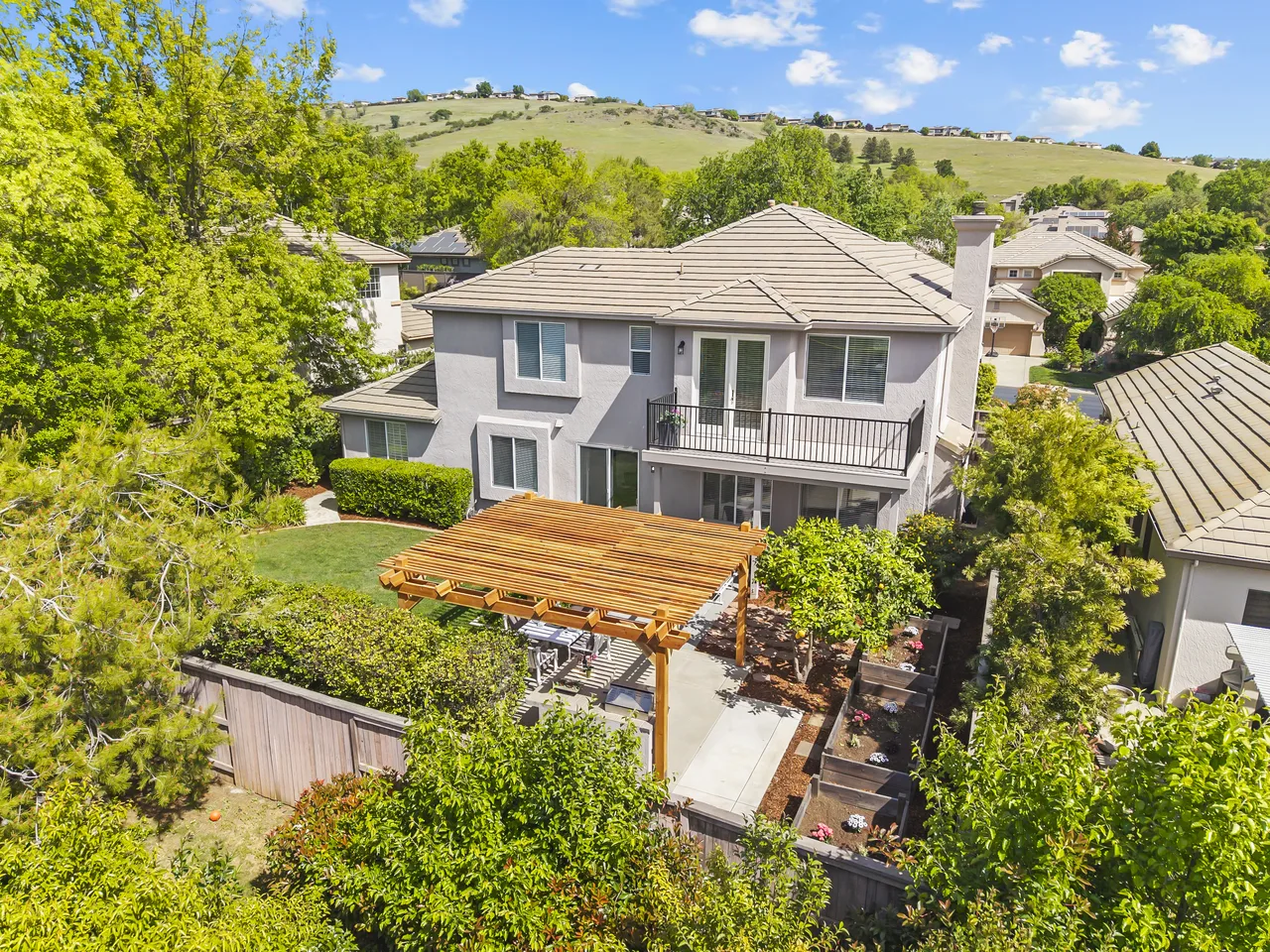 Aerial backyard view of luxury home with pergola